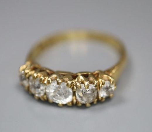 An 18k yellow metal and graduated five stone diamond set half hoop ring, size O, gross 3.8 grams,
